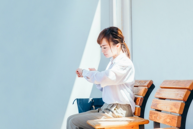 営業担当が時間を気にして時計を見るシーン